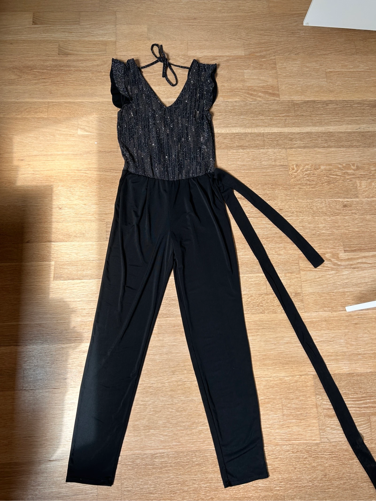 Feestelijke zwarte jumpsuit met V-hals en glitters